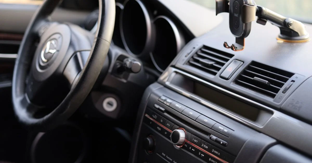 Gros plan sur un tableau de bord de voiture avec un volant et un support de téléphone, idéal pour des informations automobiles.