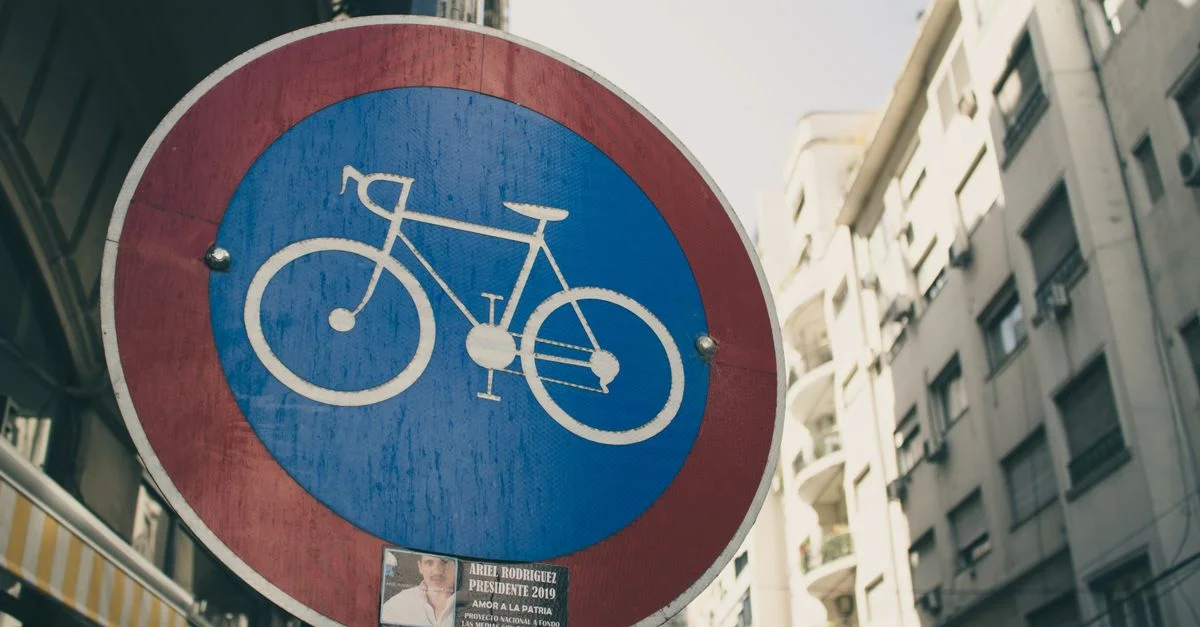 Un panneau de voie cyclable contre un fond de rue urbaine pendant la journée.
