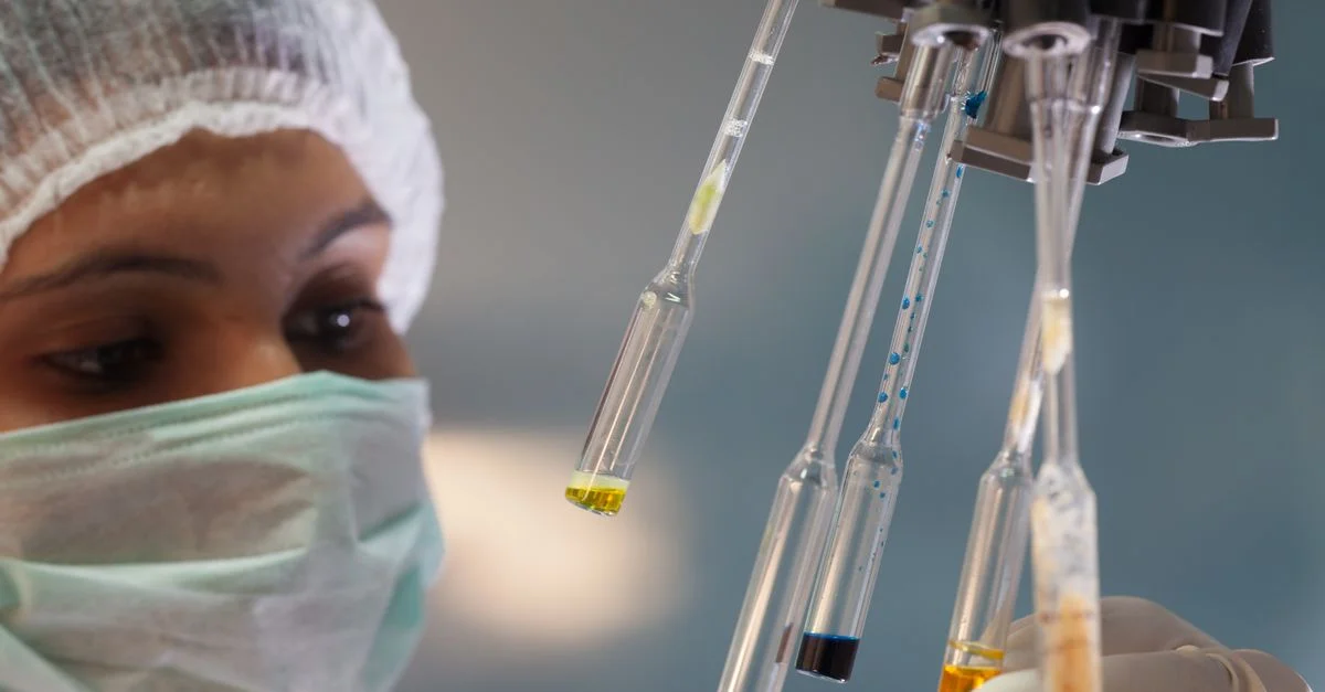 Femme scientifique dans un laboratoire manipulant des tubes à essai avec précision et concentration.