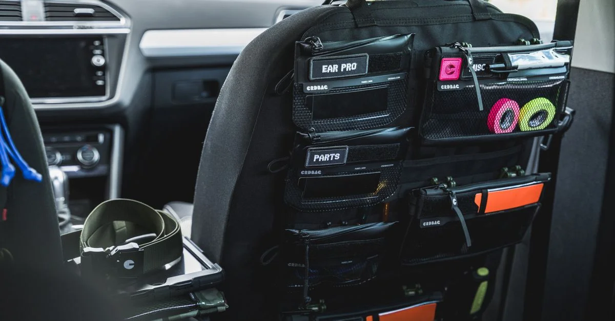 Organisateur de dossier de siège d'auto avec poches étiquetées pour le rangement des accessoires et du matériel.
